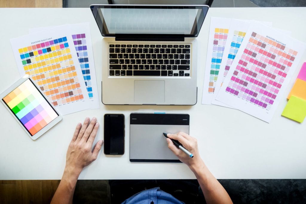 Top view of a young graphic designer working on a desktop comput